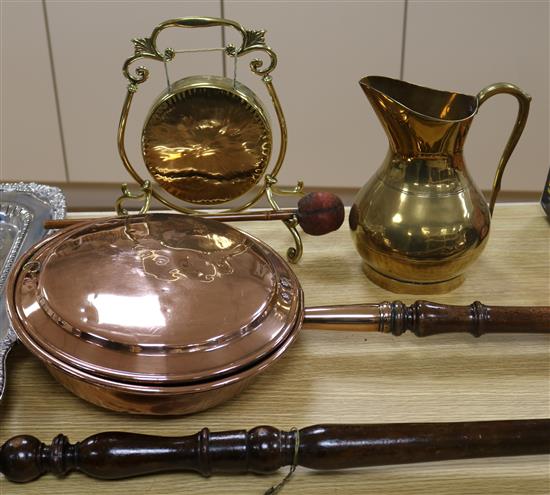 Two Victorian copper warming pans, a brass jug and a brass gong, stand and beater